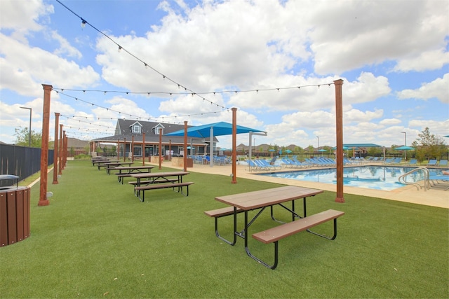 surrounding community featuring fence, a pool, and a lawn