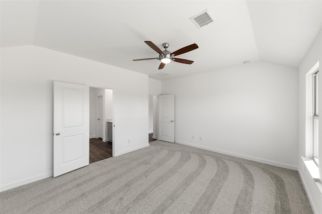 unfurnished bedroom featuring visible vents, carpet flooring, vaulted ceiling, ceiling fan, and baseboards