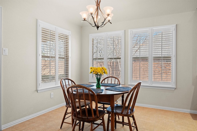 dining space featuring a chandelier, light tile patterned flooring, and baseboards