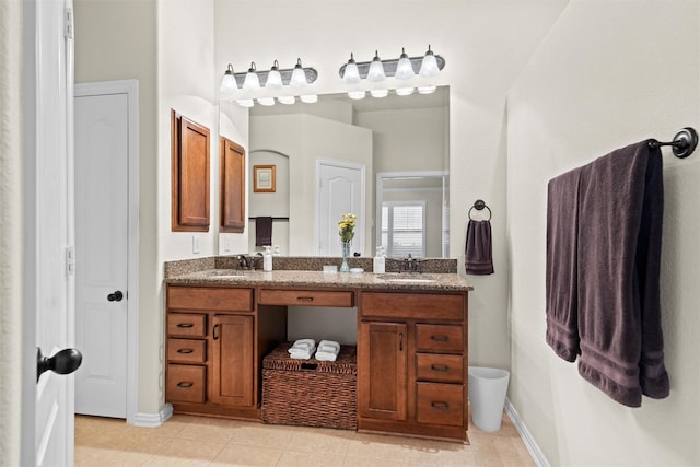 full bathroom featuring double vanity, tile patterned flooring, a sink, and baseboards