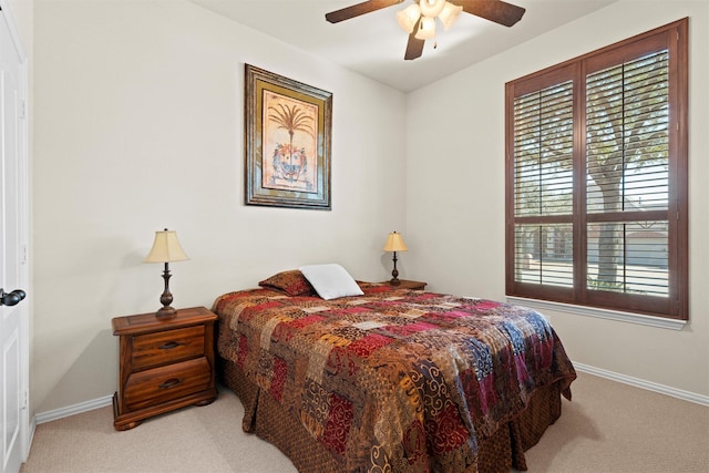 carpeted bedroom with a ceiling fan and baseboards