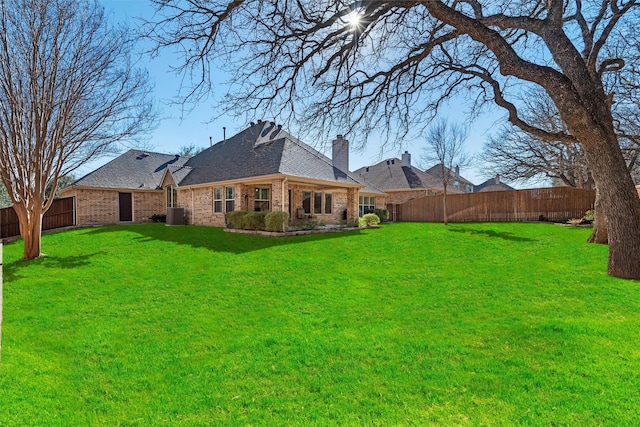 view of yard with a fenced backyard and central AC