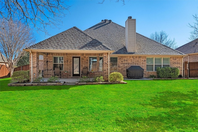 back of house with a yard, a patio area, fence, and brick siding