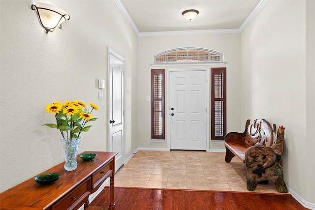 entrance foyer with ornamental molding, baseboards, and wood finished floors