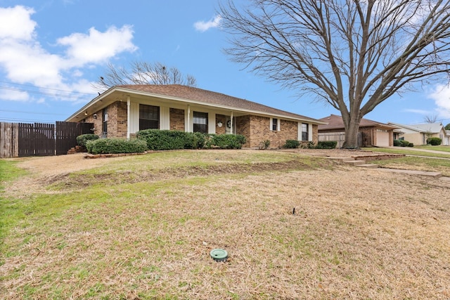 ranch-style home featuring an attached garage, brick siding, fence, and a front lawn