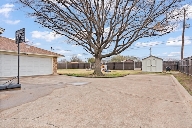 view of yard with a fenced backyard, a storage unit, and an outdoor structure