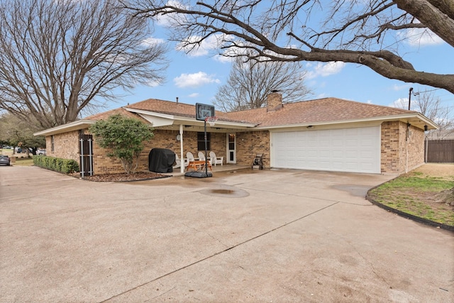 single story home with brick siding, roof with shingles, a chimney, a garage, and driveway