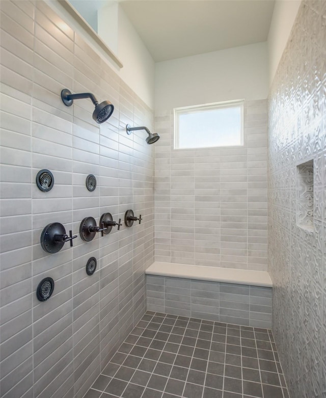 bathroom with tile patterned flooring and a tile shower