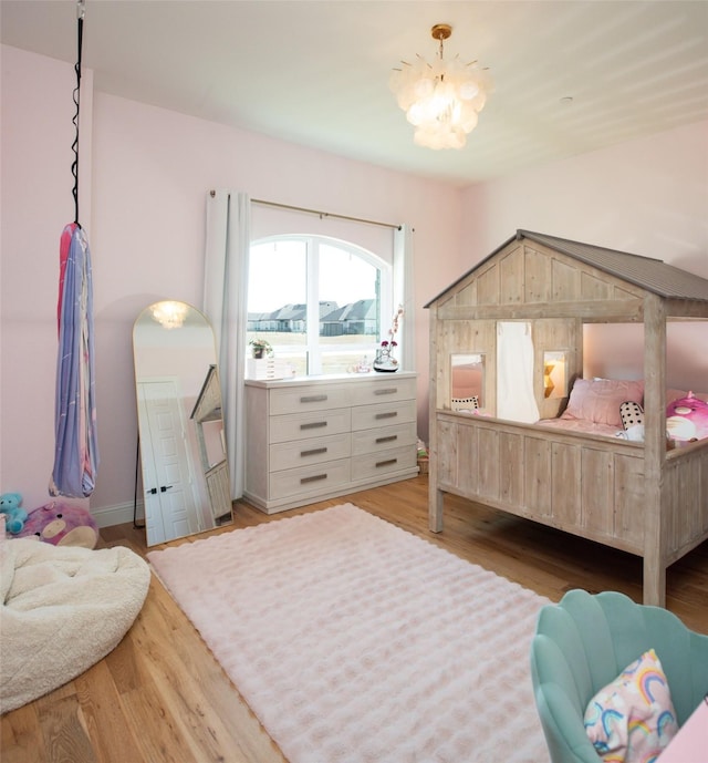 bedroom featuring a chandelier and wood finished floors