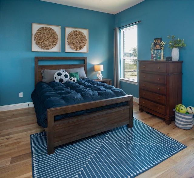 bedroom with baseboards and wood finished floors