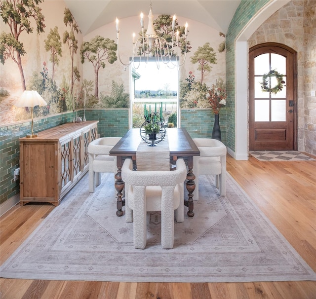 dining room with lofted ceiling, a wealth of natural light, and wood finished floors