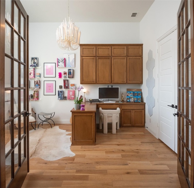 home office featuring light wood-type flooring, french doors, and visible vents