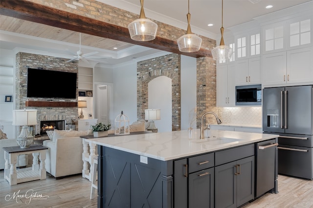 kitchen with high end refrigerator, a sink, white cabinets, gray cabinets, and built in microwave