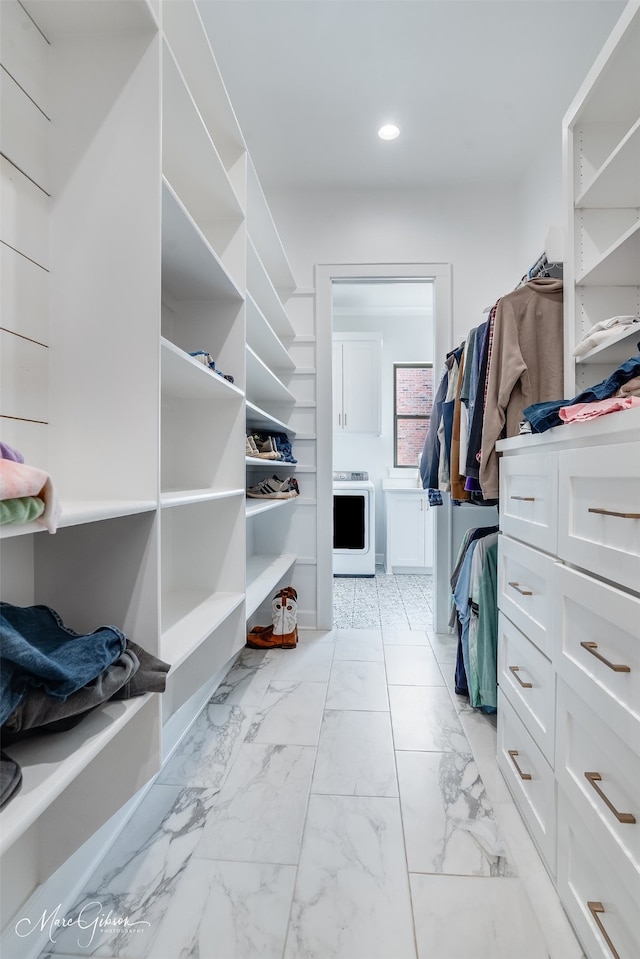 spacious closet featuring marble finish floor and washer / dryer