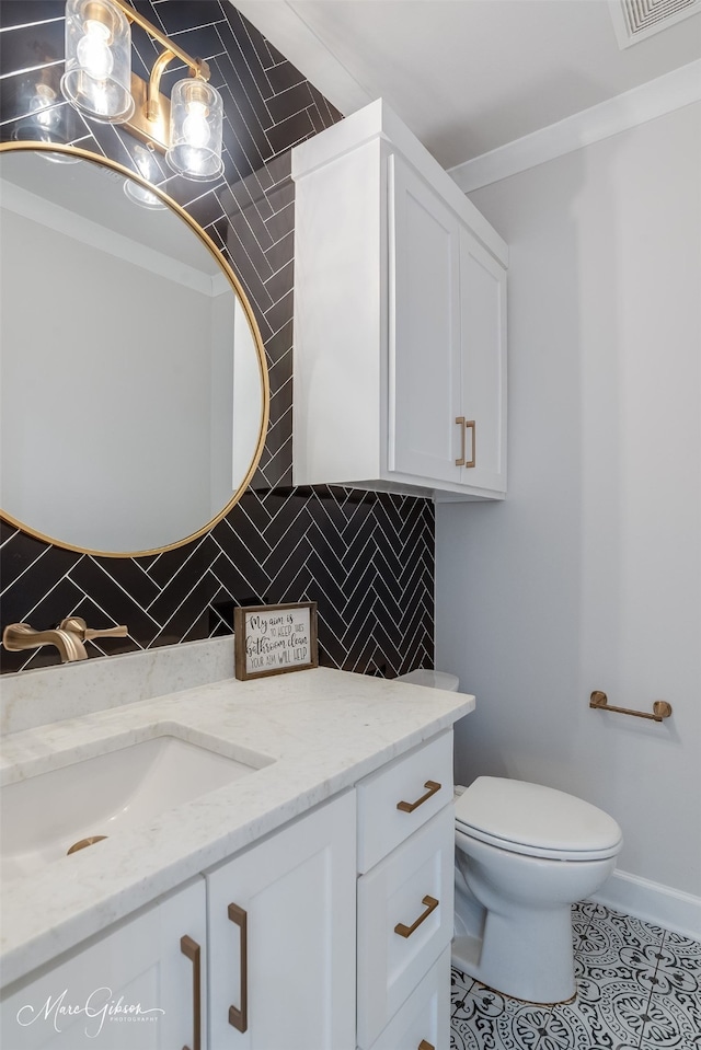 half bath featuring tasteful backsplash, toilet, ornamental molding, vanity, and tile patterned floors