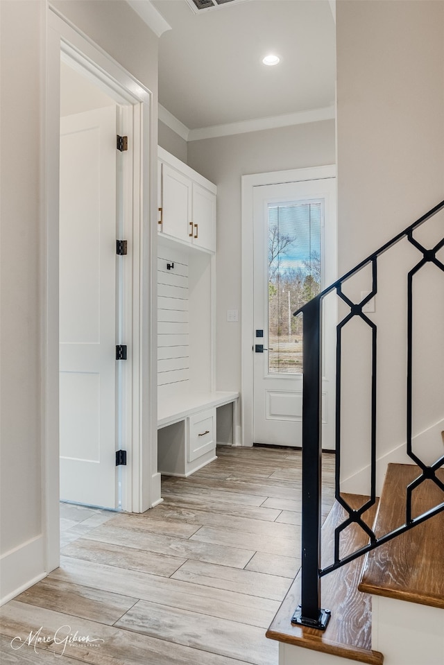 mudroom featuring light wood-style floors, recessed lighting, built in study area, and crown molding