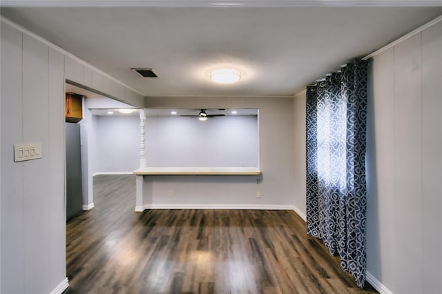 empty room featuring a ceiling fan, baseboards, visible vents, and dark wood-style flooring