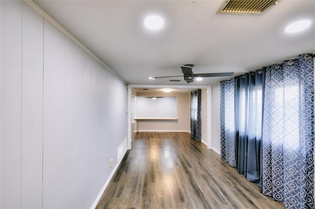 unfurnished room featuring baseboards, ceiling fan, visible vents, and wood finished floors