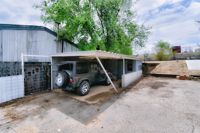 view of parking / parking lot with a carport and a pole building