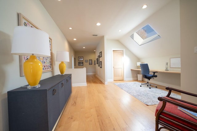 office space with vaulted ceiling with skylight, light wood-style flooring, recessed lighting, visible vents, and baseboards