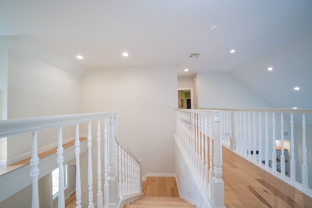 corridor featuring an upstairs landing, visible vents, wood finished floors, and recessed lighting