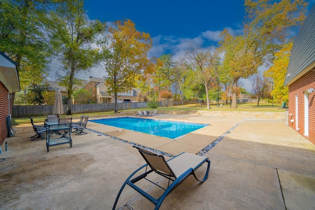 view of swimming pool with outdoor dining space, a fenced backyard, a fenced in pool, and a patio