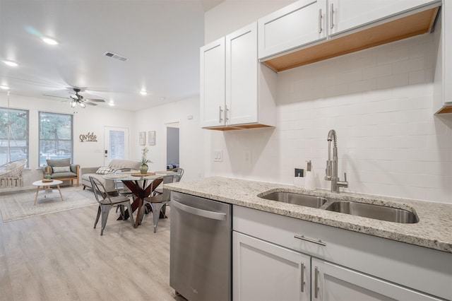 kitchen featuring a sink, visible vents, light wood-style floors, dishwasher, and tasteful backsplash