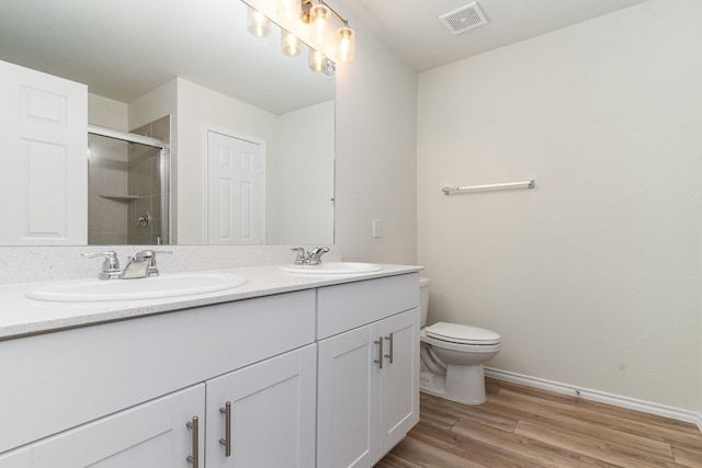 full bathroom with wood finished floors, a stall shower, a sink, and visible vents