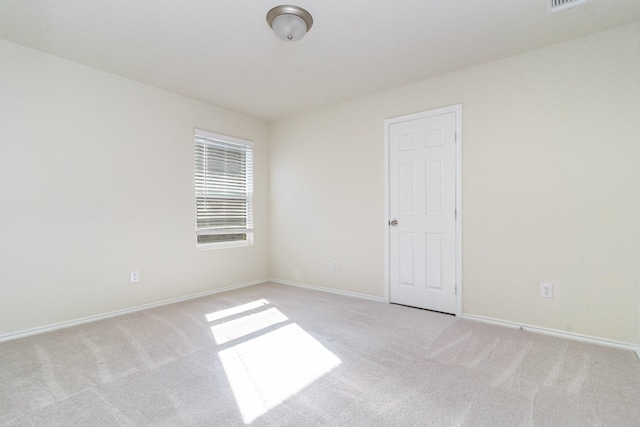 unfurnished room featuring visible vents, baseboards, and light colored carpet