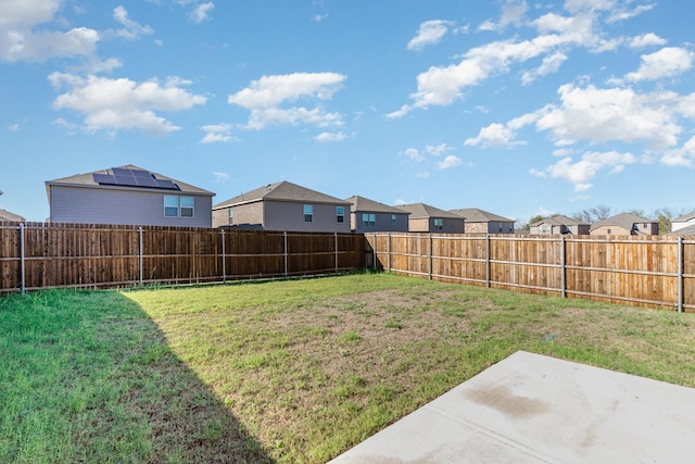 view of yard with a patio area, a fenced backyard, and a residential view