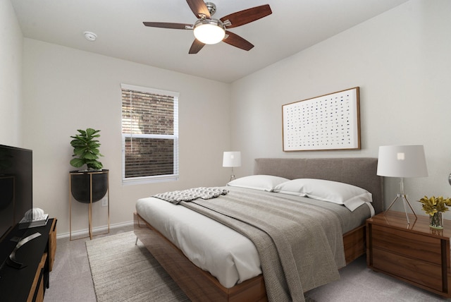 bedroom featuring a ceiling fan, light colored carpet, and baseboards