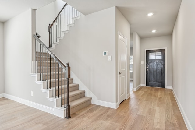 entryway with stairs, recessed lighting, light wood-type flooring, and baseboards