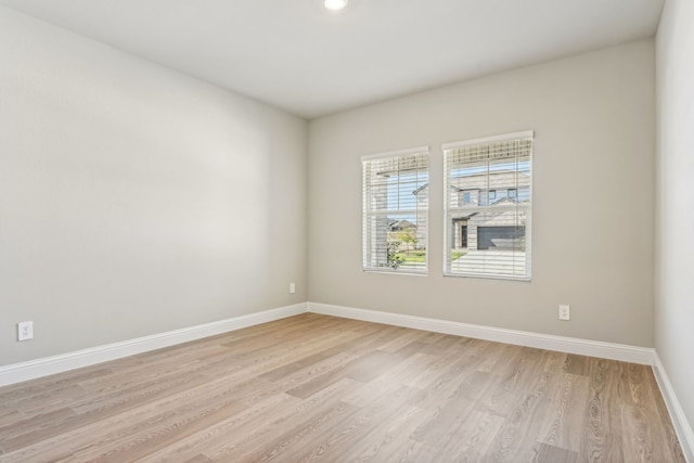 empty room with light wood finished floors and baseboards