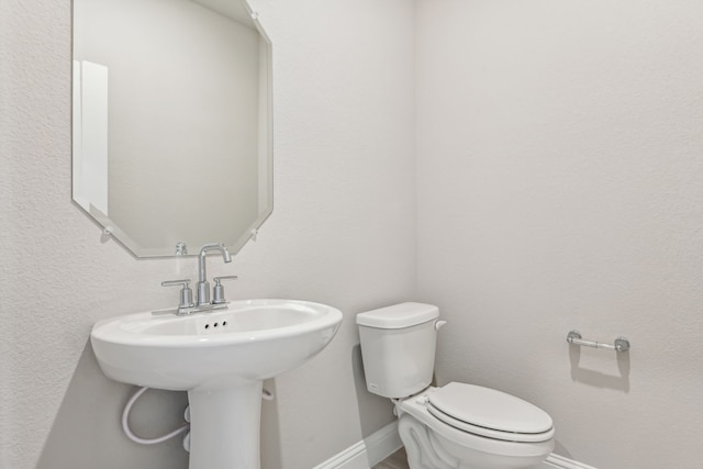 bathroom featuring toilet and baseboards