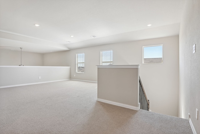 empty room featuring a healthy amount of sunlight, carpet, baseboards, and recessed lighting