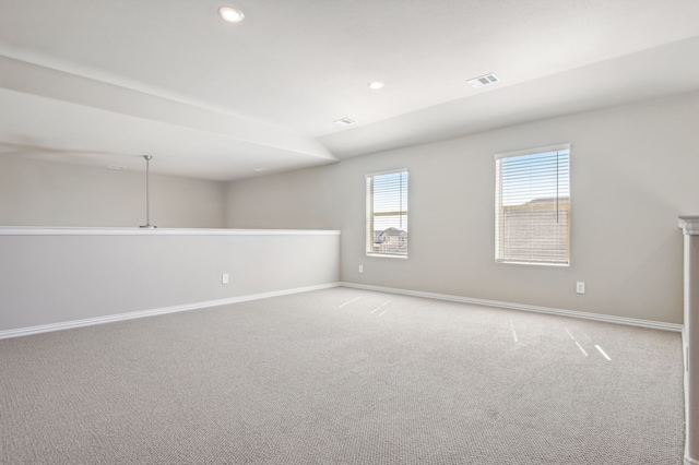 unfurnished room featuring light colored carpet, visible vents, and baseboards