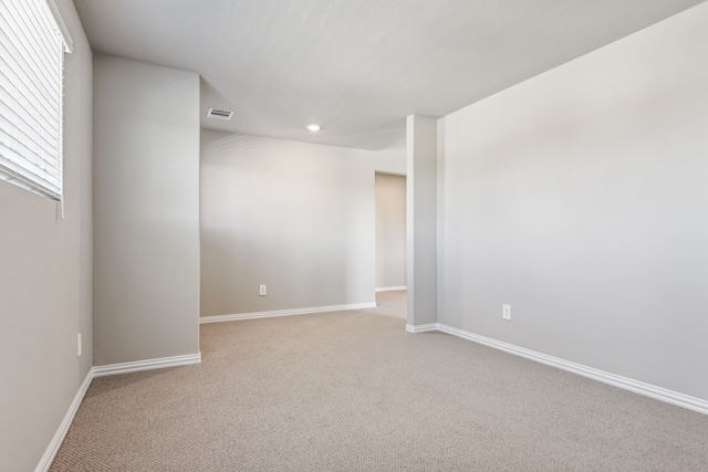 spare room featuring recessed lighting, carpet flooring, visible vents, and baseboards