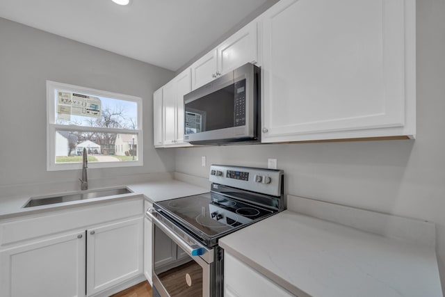 kitchen featuring a sink, light countertops, white cabinets, and stainless steel appliances