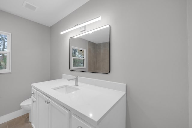 bathroom featuring visible vents, baseboards, toilet, tile patterned floors, and vanity