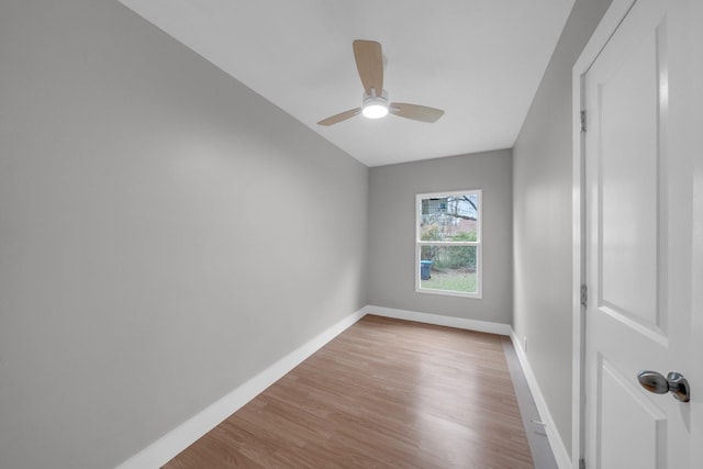 spare room with a ceiling fan, baseboards, and light wood finished floors