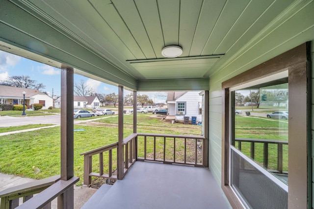 sunroom featuring a residential view and wooden ceiling