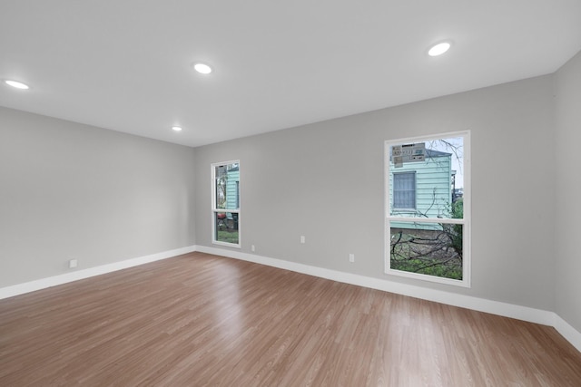 spare room with recessed lighting, baseboards, and light wood-type flooring