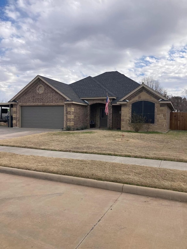 ranch-style house with an attached garage, brick siding, concrete driveway, roof with shingles, and a front lawn