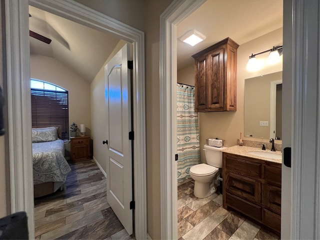 full bathroom featuring vaulted ceiling, vanity, toilet, and ensuite bath