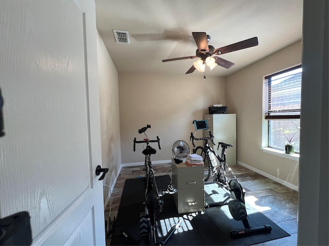 exercise room with visible vents, ceiling fan, and baseboards