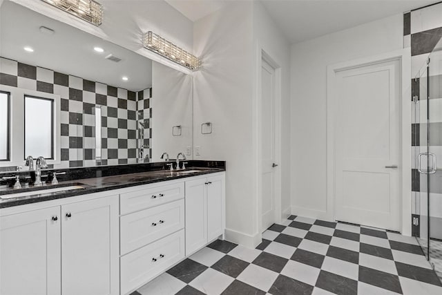 full bathroom featuring double vanity, visible vents, tile patterned floors, a shower stall, and a sink