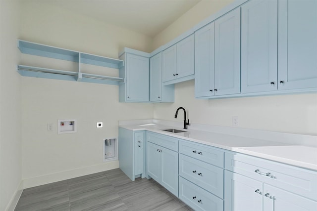 washroom featuring cabinet space, baseboards, a sink, washer hookup, and electric dryer hookup