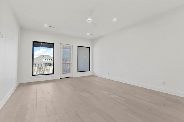 empty room featuring ceiling fan, light wood-type flooring, visible vents, and baseboards