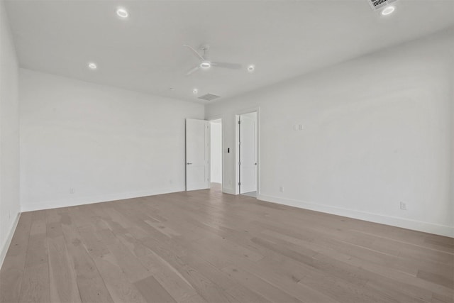 spare room with light wood finished floors, baseboards, visible vents, and ceiling fan