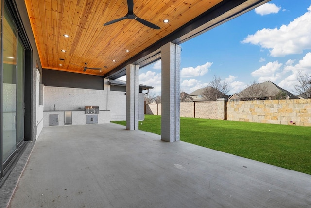 view of patio / terrace with ceiling fan, an outdoor kitchen, and fence